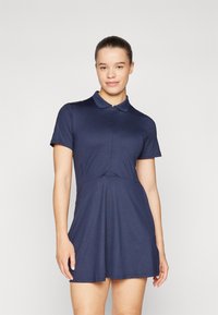 Morska polo haljina izrađena od glatkog materijala, s ovratnikom, kratkim rukavima, prilagođenim korpusom i lepršavom suknjom.