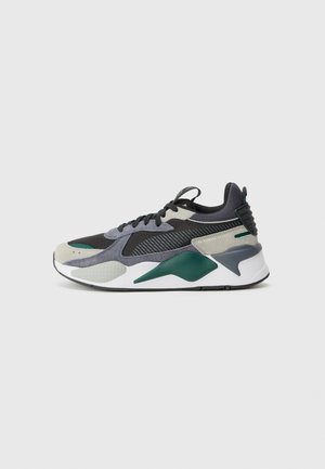Sport sneaker featuring a mix of black, grey, and green materials, textured overlays, and a white sole with angular accents.