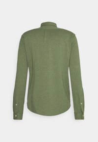 Zielona koszula z długim rękawem, zapinana na guziki, z kołnierzykiem, widok z tyłu, pokazująca zapięte mankiety i delikatną teksturę materiału.