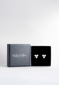 Silberne Ohrstecker mit drei klaren Steinen in einer dreieckigen Anordnung, präsentiert in einer schwarz samtgefütterten Box. Die Box hat ein strukturiertes graues Äußeres.