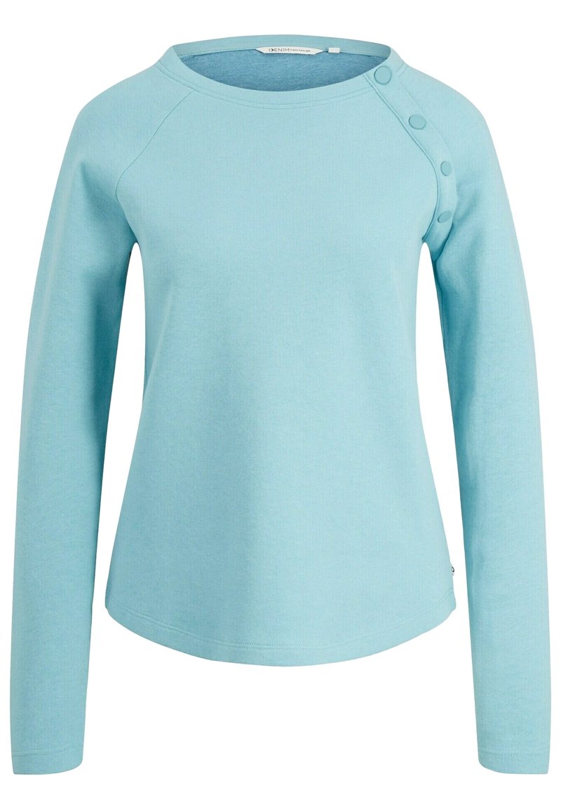 Light blue long-sleeve top with a rounded neckline, raglan sleeves, and button accents on one shoulder. Made from a soft, textured fabric.