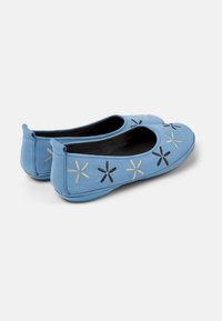 Hellblaue Ballerinas aus glattem Stoff, mit gestickten Blumenmotiven in Schwarz und Gold, runder Zehenpartie und flexibler Sohle.