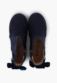 Stivaletti in suede blu navy con cerniere laterali, caratterizzati da fiocchi testurizzati sul tallone e una morbida fodera interna.