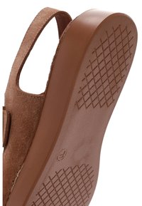 Sandale à bride arrière avec dessus en daim et semelle épaisse en caoutchouc présentant un motif de crampons croisés dans des tons marron.