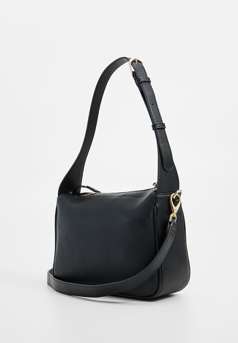 Sac à bandoulière en cuir noir avec une finition texturée, une sangle ajustable et des éléments en métal doré. Forme rectangulaire compacte.
