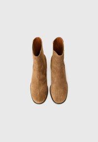 Brown suede ankle boots with a smooth finish, elastic side panels, minimalistic design, and a rounded toe. Flat rubber outsole.