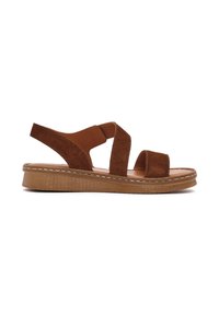 Bruine suede sandaal met twee brede bandjes en rugsteun. Rubberen zool met een gestructureerde afwerking en decoratieve stiksels langs de rand.