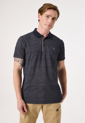 Polo shirt bleu marine avec une texture ornée de motifs de feuilles, un col contrastant et un logo embellissant sur la poitrine. Manches courtes.