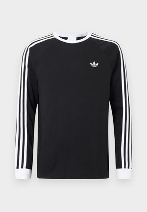 Maglietta nera a maniche lunghe con design a tre strisce bianche sulle maniche. Presenta una scollatura rotonda e un piccolo logo bianco sul petto.