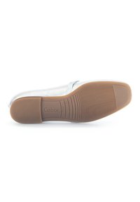 Flache Schuhe mit einem glänzenden silbernen Obermaterial, das eine glatte Textur aufweist, sowie einer hellbraunen Gummisohle mit einem gerippten Muster für besseren Halt.