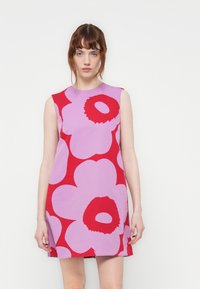 Rochie fără mâneci, de culoare violet deschis, cu modele florale mari în nuanțe de roșu și roz. Croială dreaptă, până la genunchi, confecționată dintr-un material moale.