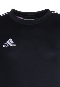 Zwarte sportshirt gemaakt van textuurstof met een ronde hals. Beschikt over het witte Adidas-logo aan de linkerkant en witte strepen op de mouwen.