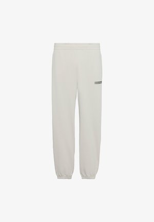 Ανοιχτό μπεζ φόρμα με ελαστική μέση και μανσέτες, με μικρό λογότυπο Calvin Klein στο πάνω μέρος του μηρού.