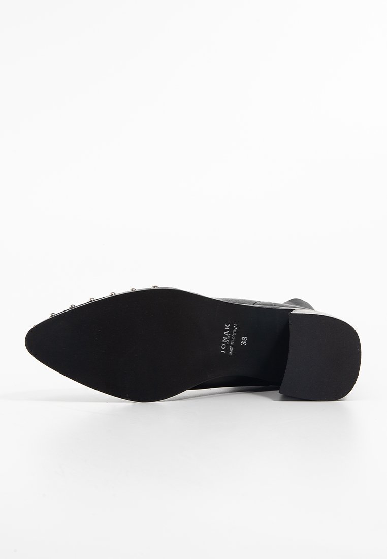 Schwarzer Absatzschuh mit glattem Lederoberteil und dekorativen Metallnieten an der Seite. Flauschige Gummisohle mit runder Zehenpartie und minimalem Branding.