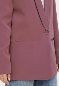 Lila Blazer mit einem Einzelknopfverschluss, einem Reverskragen und einer Fronttasche sowie einer glatten Textur.
