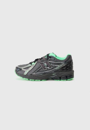 Czarno-zielony but do biegania New Balance z siateczkową cholewką i grubą amortyzowaną podeszwą, pokazany z boku na prostym szarym tle.