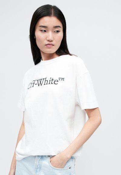 Valge puuvillane T-särk, millel on must "Off-White™" logo. Lühikesed varrukad ja lai lõige, mida täiustab ümar kaelus.