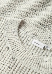 Pull en tricot gris clair avec un motif texturé, col côtelé et une petite étiquette blanche avec "name it" imprimé dessus.