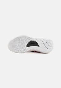 Witte rubberen sportschoenzool met gestructureerde grippatronen, voorzien van een gebogen vorm en een zwarte accent nabij de voetboog voor stabiliteit.