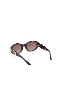 Ochelari de soare cu rame tortoise-shell, cu lentile ovale, nuanță maro și accesorii decorative din argint pe brate. Textură netedă și ramă curbată.