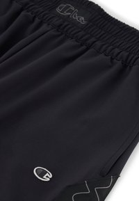 Zwarte sportshorts met een elastische tailleband, een zilveren logo aan de voorkant en een gestructureerd zwart zijpaneel met een golfpatroon.