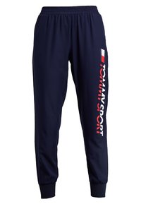 Marine joggerbroeken van gladde stof, met een elastische tailleband, manchetboorden en een groot wit en rood "TOMMY SPORT" logo aan de zijkant.