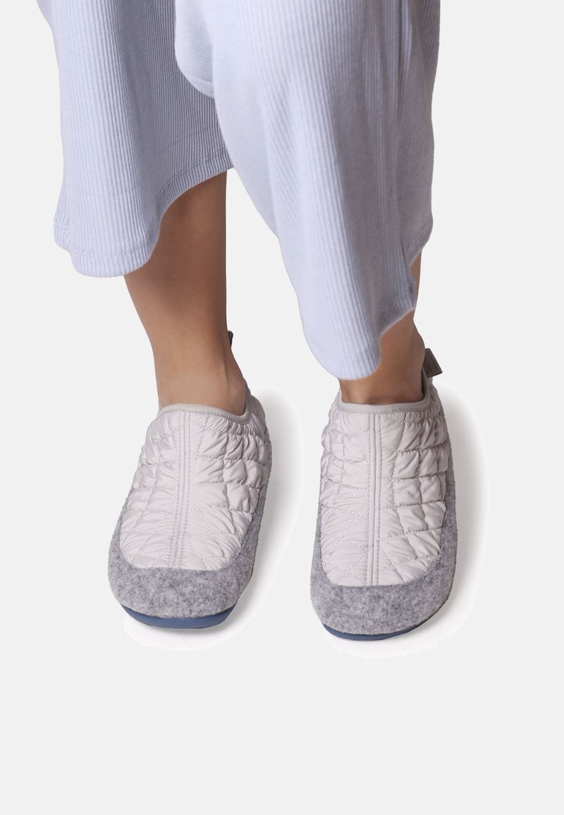 Quilted grey and light beige slippers with a soft textured upper and a grey felt sole, featuring a pull tab for easy wear.