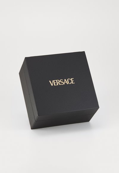 Must mustkastiga musta karbiga, millel on matt viimistlus, peal kullast "VERSACE" logo, ristküliku kujuga ja sile tekstuur.