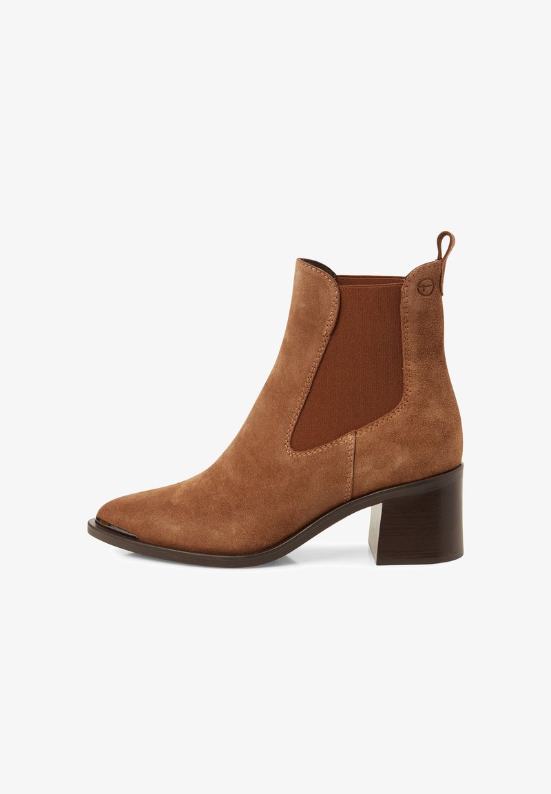 Braune Wildleder-Ankle-Boots mit spitzer Zehenpartie, elastischen Seiteneinsätzen und einem klobigen Absatz. Mit einer Zuglasche auf der Rückseite für ein einfaches An- und Ausziehen.