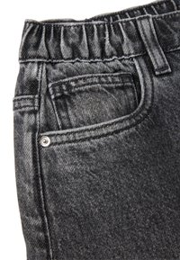Los pantalones cargo de mezclilla negros cuentan con una cinturilla con volantes, un bolsillo frontal y costuras visibles, mostrando una tela texturizada con un brillo sutil.