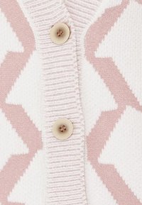 Stickad cardigan i vitt och mjukt rosa med zigzag-mönster, med en texturerad ribbad placket och en krämfärgad knapp.