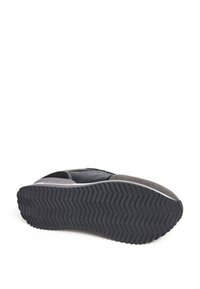 Sneaker nero e grigio con materiale superiore testurizzato, caratterizzato da una suola di gomma con un motivo a zigzag e un design del tallone imbottito.