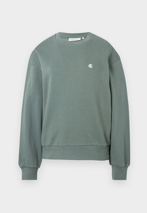 Vihreä crewneck-huppari pitkillä hihoilla, ribatut hihansuut ja helma, jossa on pieni valkoinen logo vasemmassa rinnassa.