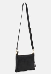Svart vävd läderaxelväska med avtagbar rem, guldfärgad hårdvaruaccents och rektangulär form med dragkedjestängning.