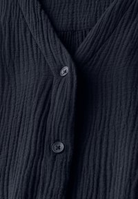 Cardigan strutturato blu navy con un design a pieghe e due bottoni neri sul davanti, con scollatura a V e un tessuto morbido.