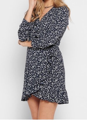 Marineblaues Blumen-Wickelkleid mit langen Ärmeln, das einen rüschendetaillierten Saum und kleine weiße Blumenmuster auf dunklem Hintergrund zeigt.