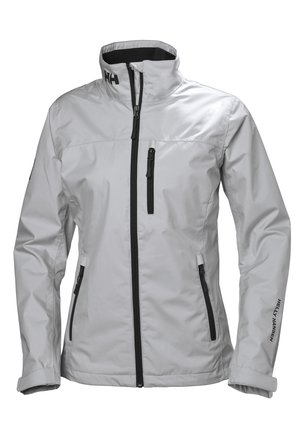 Chaqueta impermeable gris claro con cuello alto, cremalleras negras y bolsillos. Presenta un logo en el cuello y la manga. Textura suave y duradera.