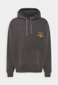 Felpa grigia realizzata in morbido tessuto, con tasca a marsupio, cappuccio con cordini e logo ricamato in giallo. Polsini e orlo a costine.