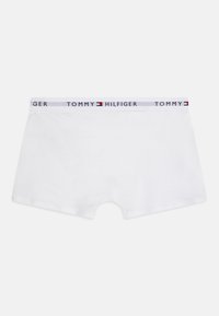 Weiße Baumwoll-Boxershorts mit einem elastischen Bund in Blau und Rot, auf dem der Text "TOMMY HILFIGER" abgebildet ist. Glatte Textur, minimalistisches Design.
