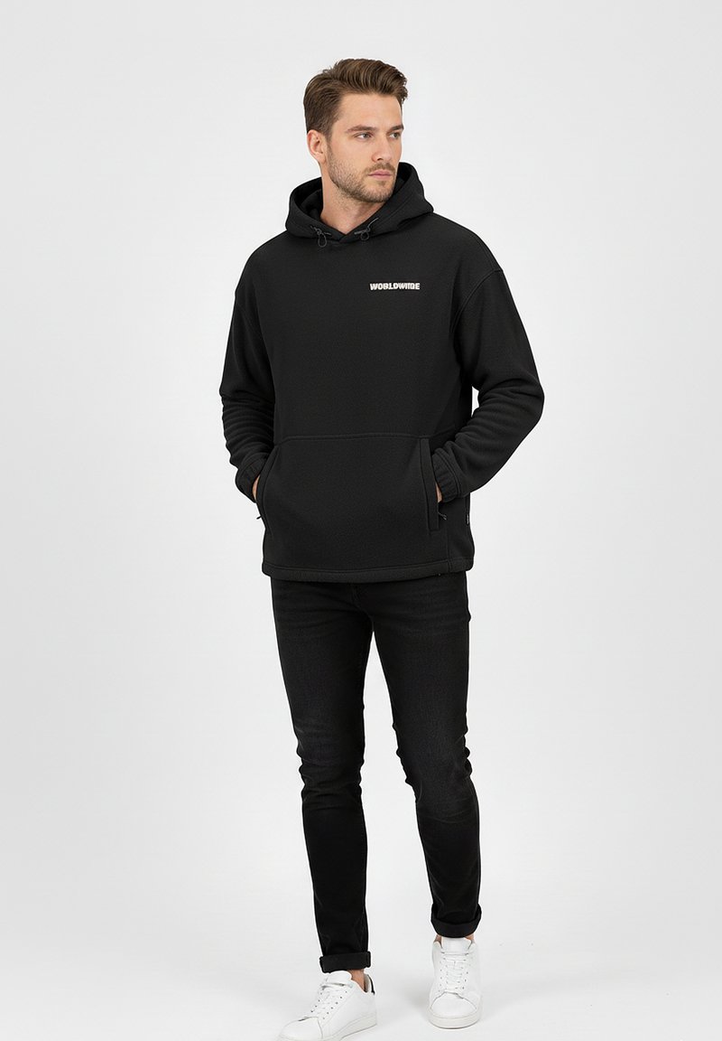 Black hoodie with a front pocket, featuring a white "WORLDWIDE" logo. Paired with black jeans and white sneakers, stands on a neutral background.