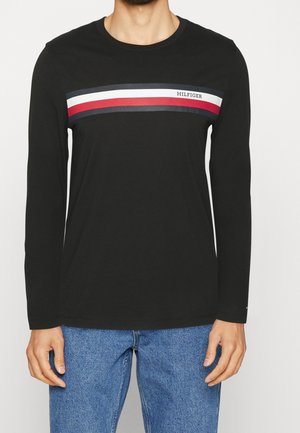 Schwarzes Langarm-T-Shirt aus Baumwolle mit horizontalem Streifendekor in Rot, Weiß und Blau auf der Brust und Markenaufdruck.
