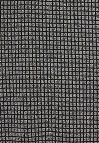 Musta teksturoitu kangas, jossa on ruudukkomalli pienillä neliöillä, jotka vaihtelevat matta- ja kiiltopintojen välillä. Ihanteellinen verhoiluun tai sisustukseen.