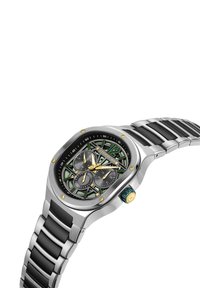 Orologio in metallo argentato con quadrante a motivo nero e verde, accenti dorati e cinturino in gomma; presenta sotto quadranti cronografici e una corona.