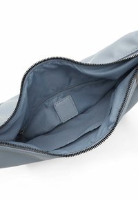 Blå läderclutch med en jämn yta, dragkedjestängning och ett tygfoder. Har en innerficka och en logotyp.