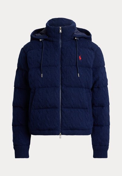 Navyblå puffjacka med kabelstickad textur, dragkedjestängning, dubbellagerhuva och en liten röd logotypprydnad på vänster bröst.