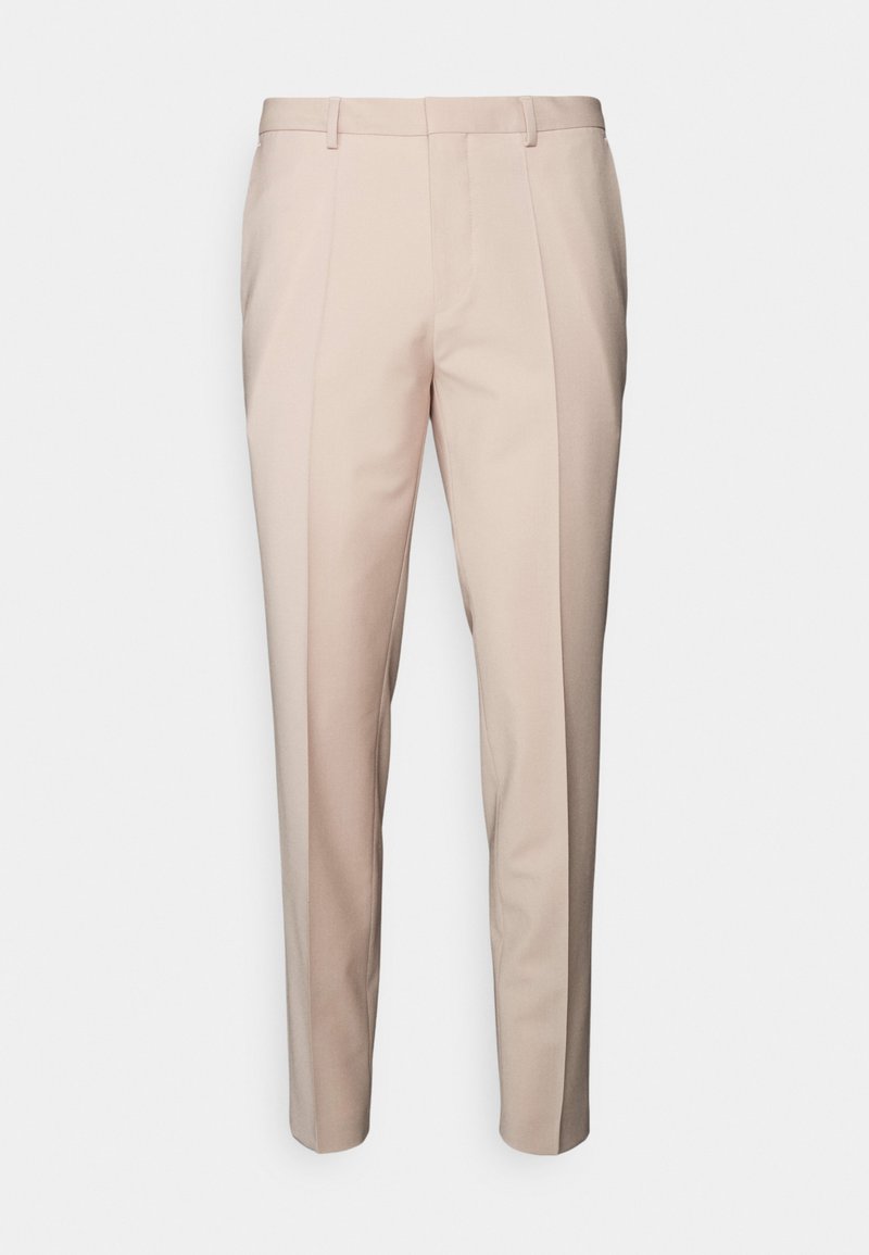 Pantalon beige ajusté à coupe droite, dotés de deux plis avant, de passants de ceinture et d'une texture de tissu lisse sur un fond uni.