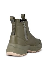 Zielono-oliwkowe skórzane botki za kostkę z zamkiem błyskawicznym, teksturowanym tylnym panelem, pętelką do zakładania oraz lekką platformą w kolorze beżowym.