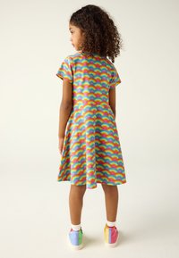 Barvita obleka z vzorcem mavrice, kratkimi rokavi, razširjenim krilom, iz gladkega blaga. Povezana s pisanimi čevlji.