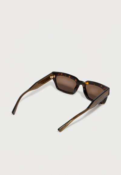 Ορθογώνια γυαλιά ηλίου με σχέδιο χελώνας, με σκούρους καφέ φακούς και χρυσές λεπτομέρειες, ανοιχτά πάνω σε λευκή επιφάνεια.