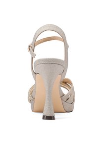 Sandal alta in beige metallizzato con cinturino alla caviglia, apertura sul retro e design incrociato. Presenta un tacco elegante e materiale testurizzato.